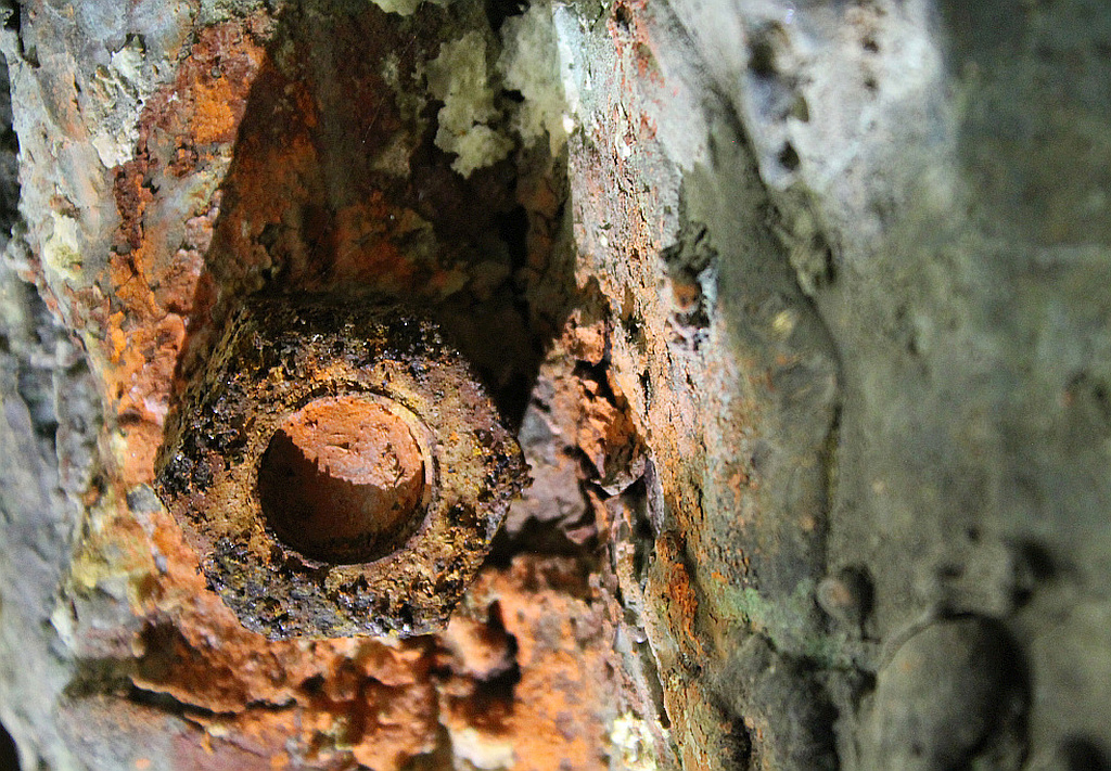 atmospheric corrosion of a galvanic pair of carbon steel bolt and the interior of a bronze sculpture